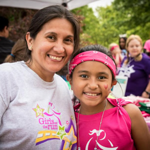 Girls on the Run coach is smiling at one of the program participant outdoors